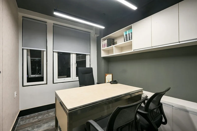 Wnętrze biura w kamienicy z wysokim sufitem i stanowiskami pracy
